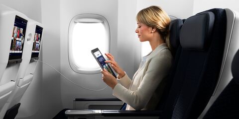 尊尚经济舱中手拿 iPad 的旅客